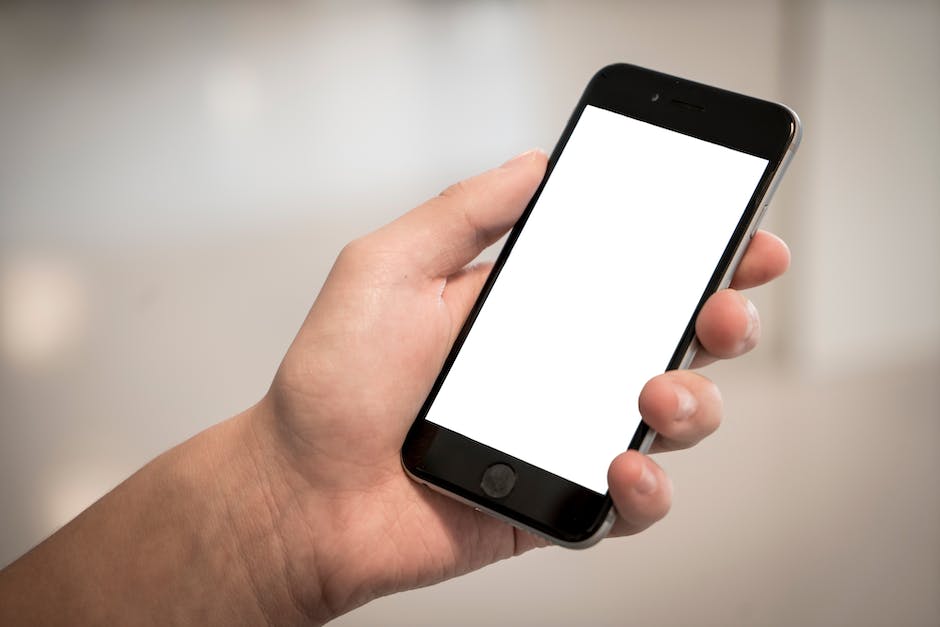 An image of a hand holding a cell phone with the Reddit homepage on the screen, showcasing a selection of investment and stock subreddits being subscribed to and targeted in the search bar.